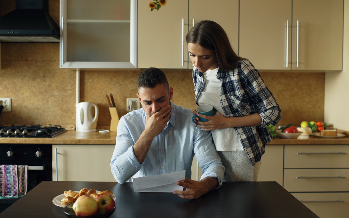 Distressed couple reviewing household bills — debt consolidation