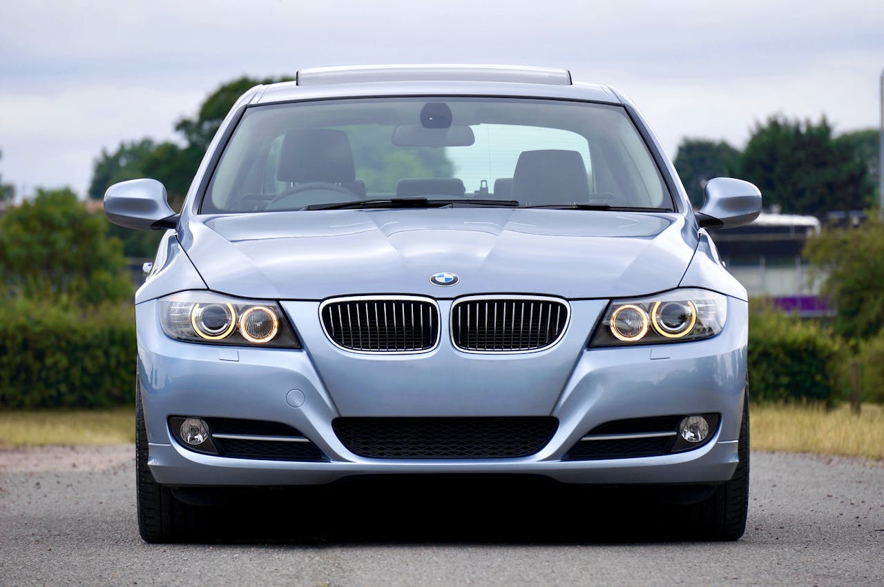 A modern blue sedan car parked on a rural road, showcasing its luxury and design.